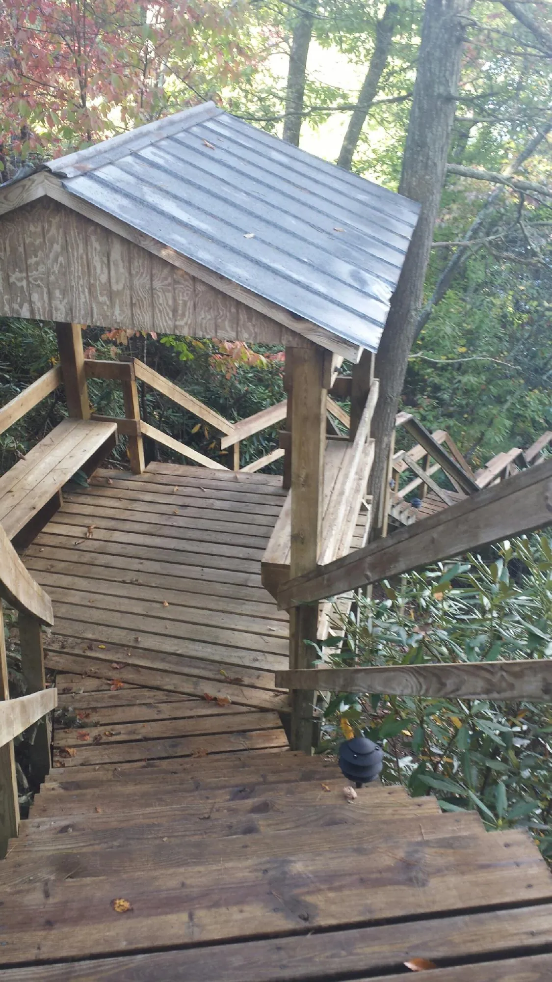 Metal roofed shelter over wooden steps on a wooded walkway — Skylight Repair & Installation work by our crew in Glen Lyon